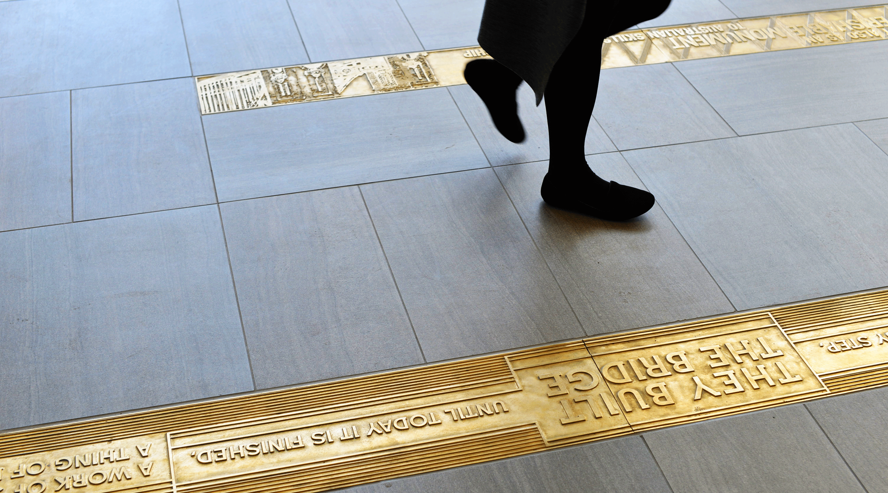 Photograph showing woman walking across ground inlays in Ennis Road Bays RMS headquarters.
