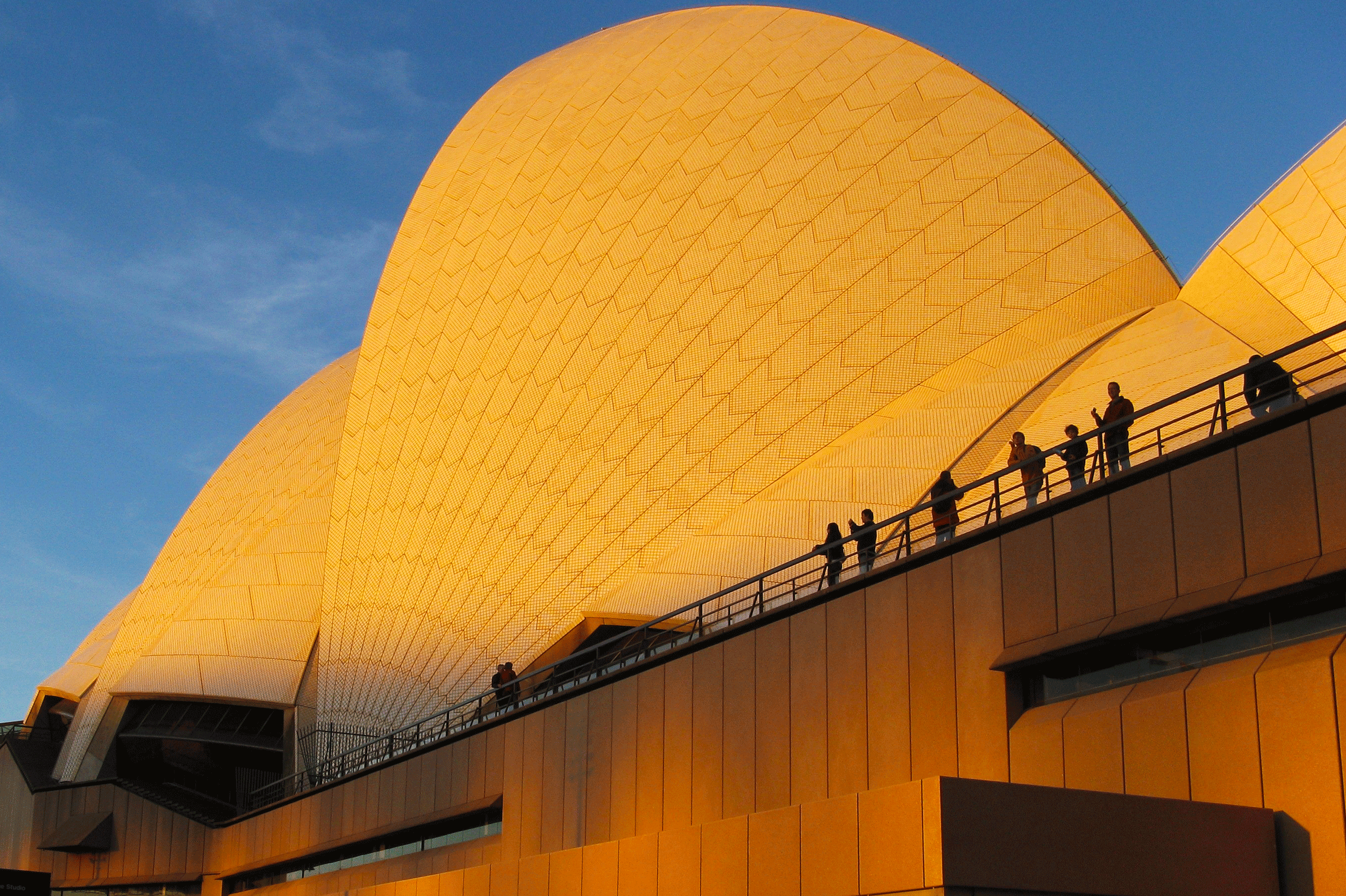 External photograph of Sydney Opera House showing white 'sails' against sky.